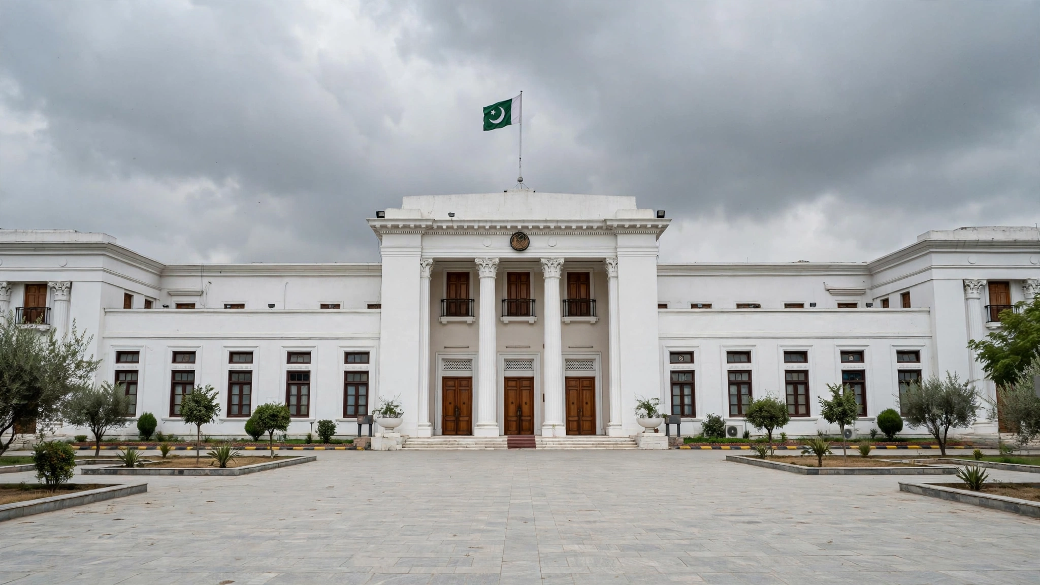 The provincial assembly building in Peshawar under a grey sky, with the Pakistani flag flying, during a period of governor's rule.