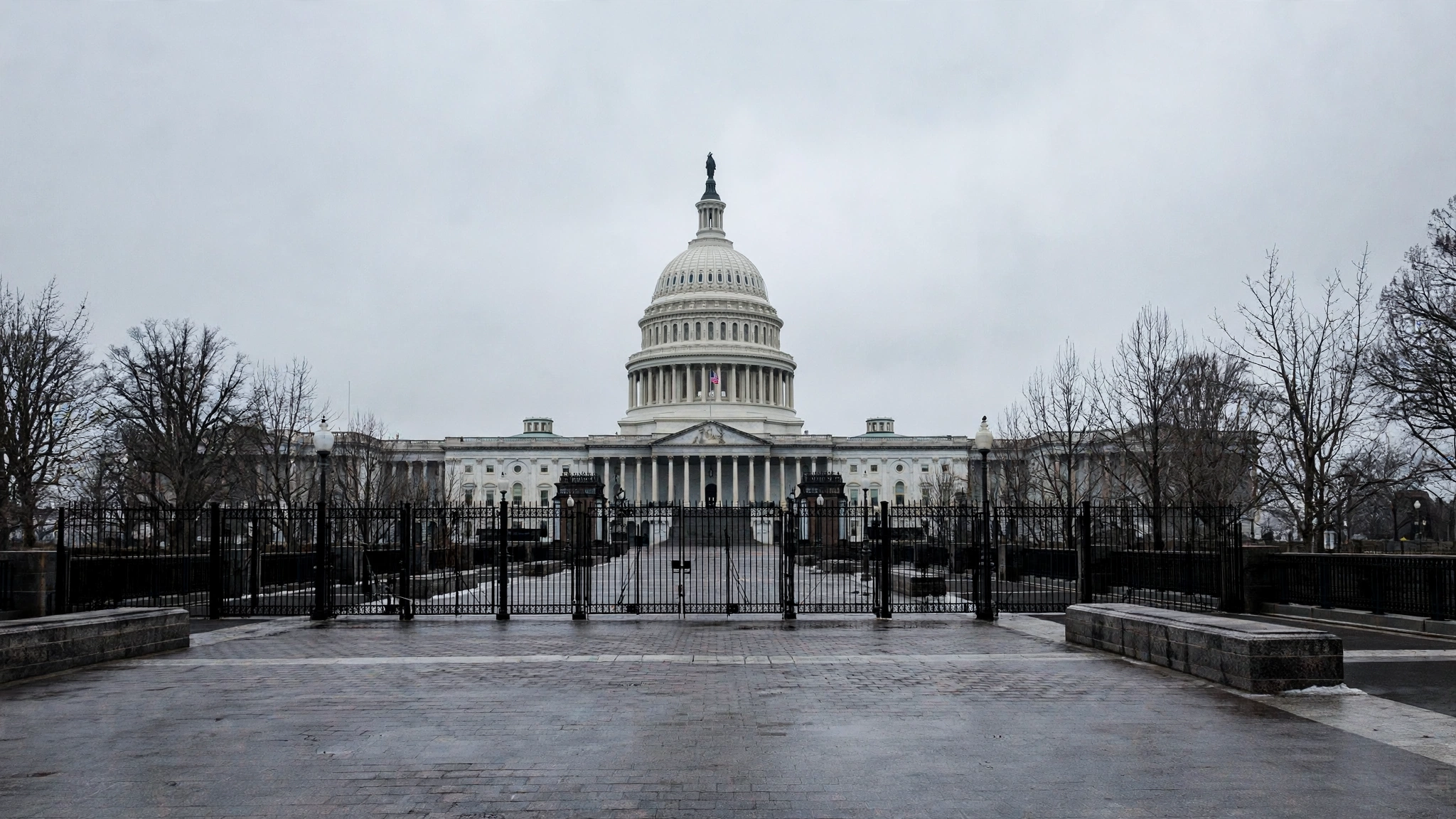 The United States Capitol building with closed gates and an empty plaza on a grey morning